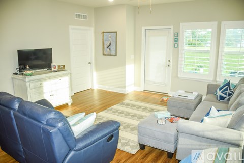 A living room with a blue leather chair and a grey sofa.