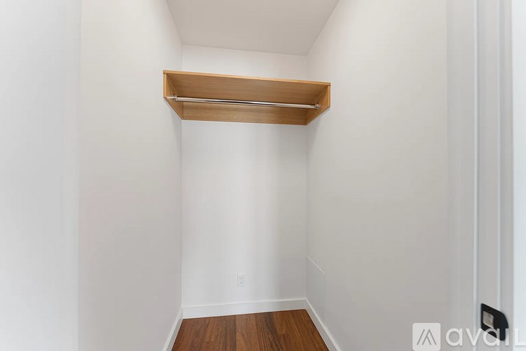 A white wall with a wooden shelf on top.