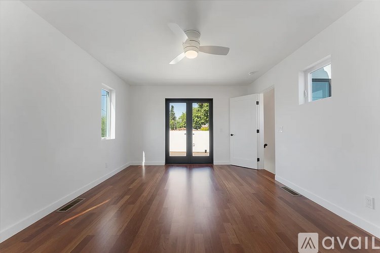 A room with wooden floors and a ceiling fan.