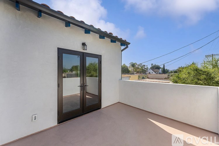 A balcony with a door and a wall.