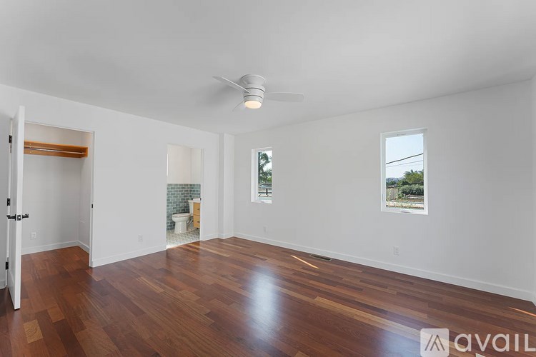 A room with wooden floors and a ceiling fan.