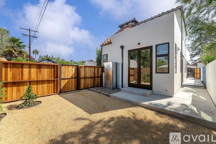 A modern house with a white exterior and a brown fence.