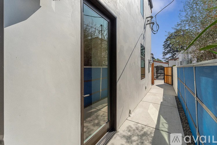 A white building with a glass door and a sign that says "available".