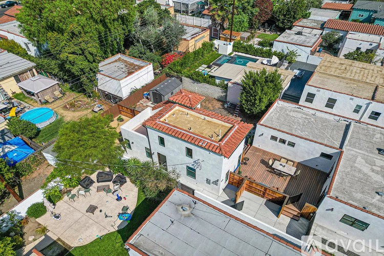 A bird's eye view of a residential area with a white house in the center.