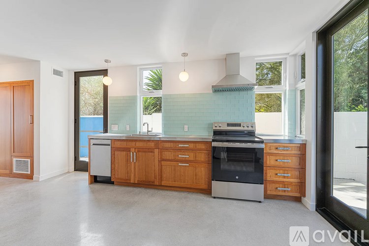 A kitchen with wooden cabinets and a stainless steel oven.