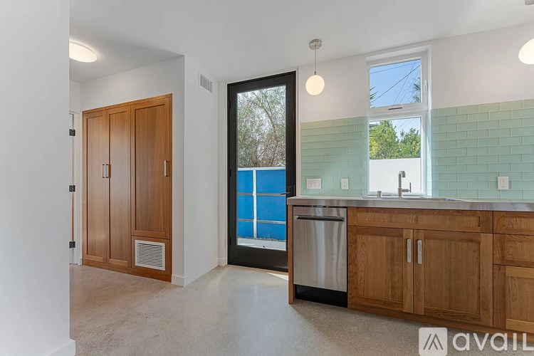 A kitchen with wooden cabinets and a black fridge.