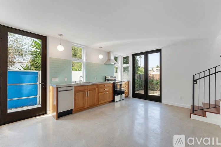 A spacious kitchen with wooden cabinets and a blue glass backsplash.