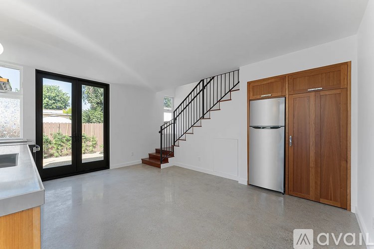 A kitchen area with a stainless steel refrigerator and a wooden door.