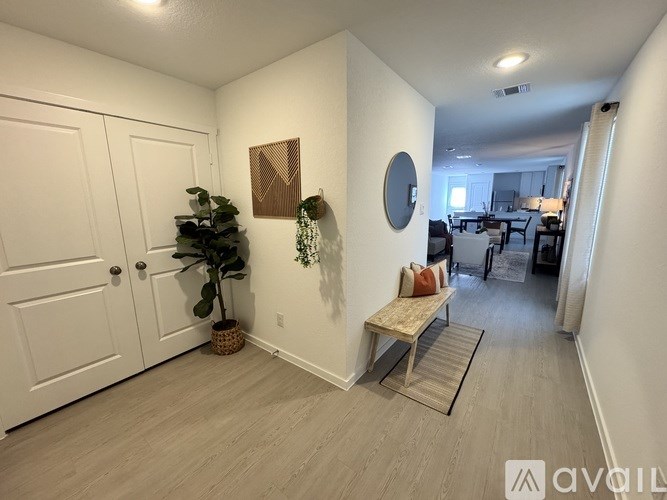 A room with a bench, a mirror, and a potted plant.