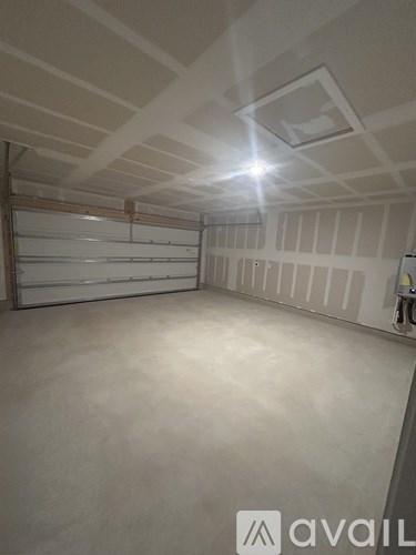 A spacious garage with a white ceiling and a closed white door.