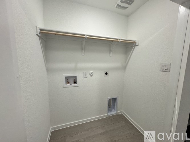 A white wall with a shelf and a light switch.