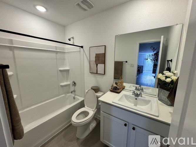 A bathroom with a toilet, sink, and mirror.