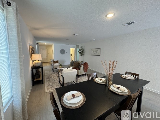 A dining room with a black table set for two.