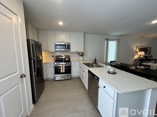 A kitchen with white cabinets and black appliances.