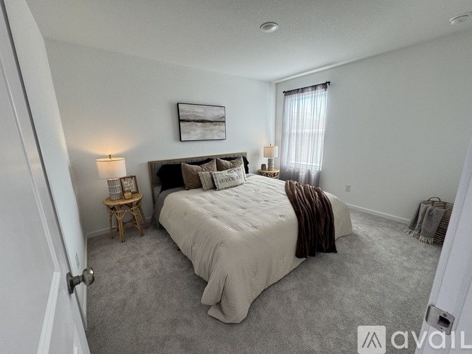 A bedroom with a large bed and a painting on the wall.