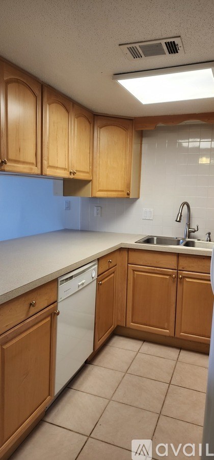 A kitchen with wooden cabinets and a white dishwasher.