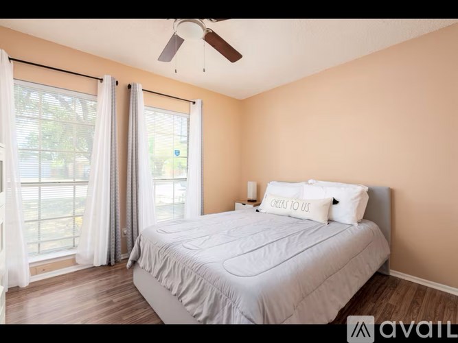 A bedroom with a large bed and a ceiling fan.