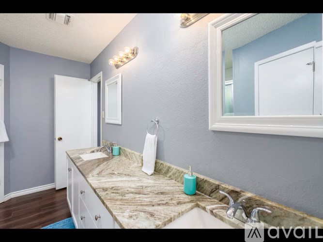 A bathroom with a marble countertop and a large mirror.