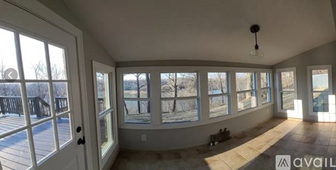 A sunny room with a view of a snowy landscape outside the windows.