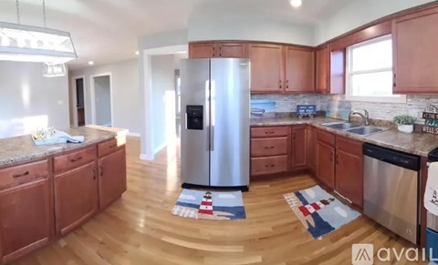 A kitchen with wooden cabinets and a stainless steel refrigerator.