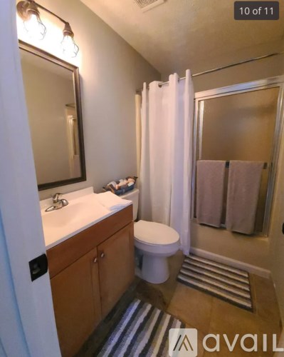 A bathroom with a toilet, sink, and shower.