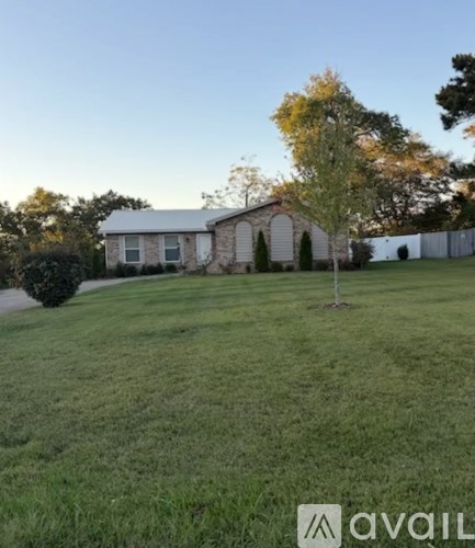 A house with a white fence and a tree in front of it.