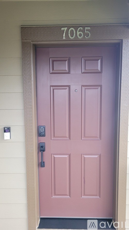 A purple door with the number 7065 above it.