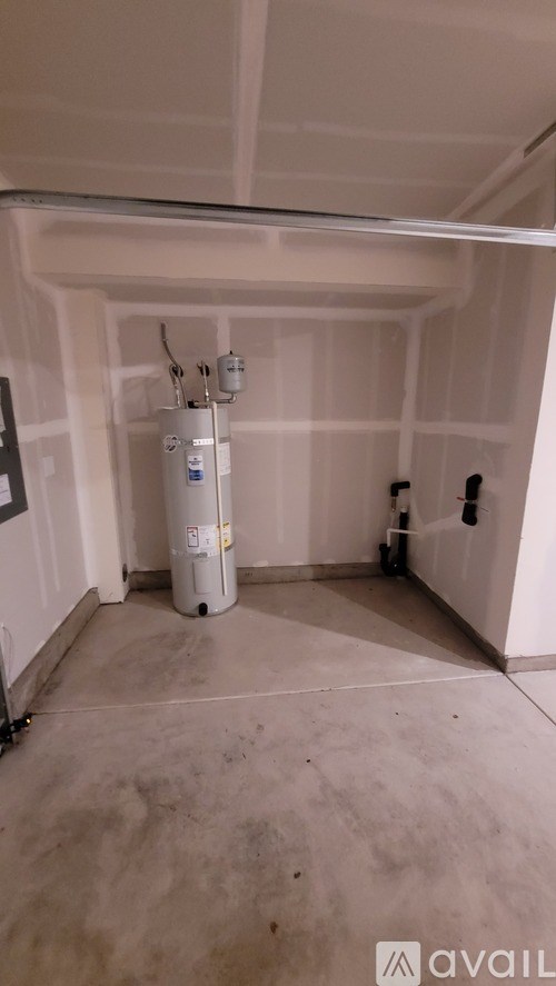 A room with a water heater and pipes.