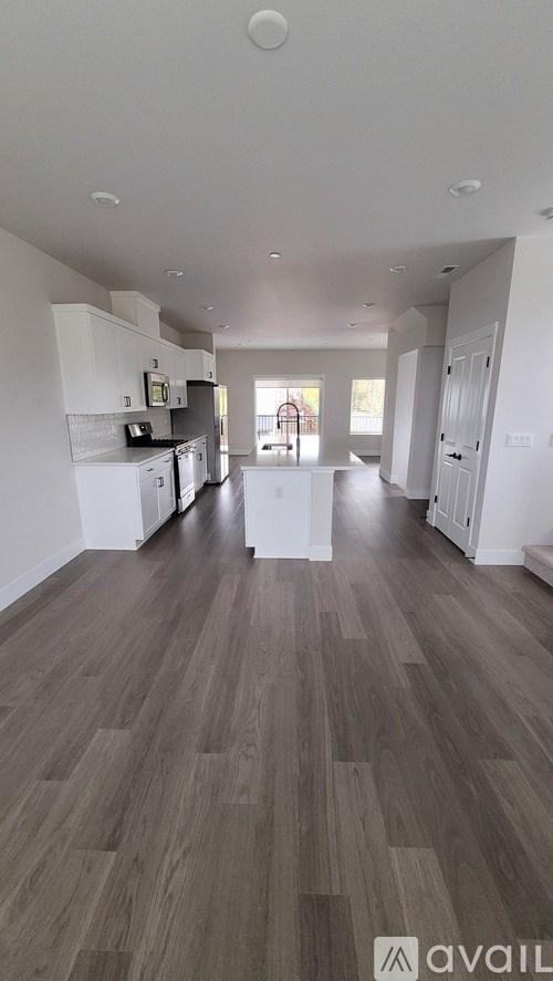 A spacious kitchen with white cabinets and a microwave.