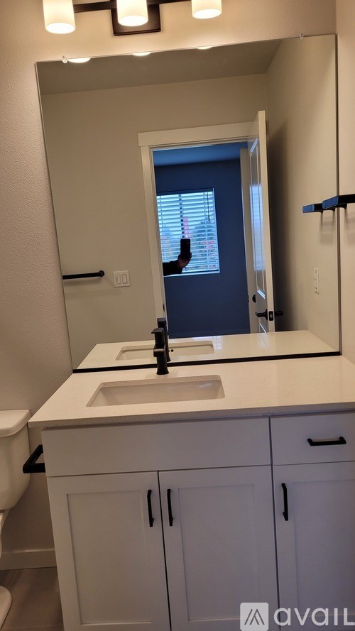 A bathroom with a sink, mirror, and cabinets.