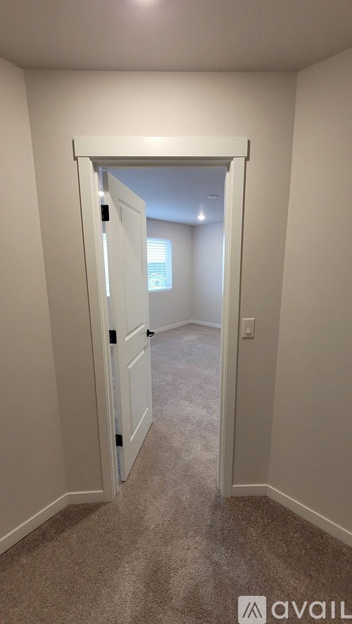 A room with a carpeted floor and a white door.