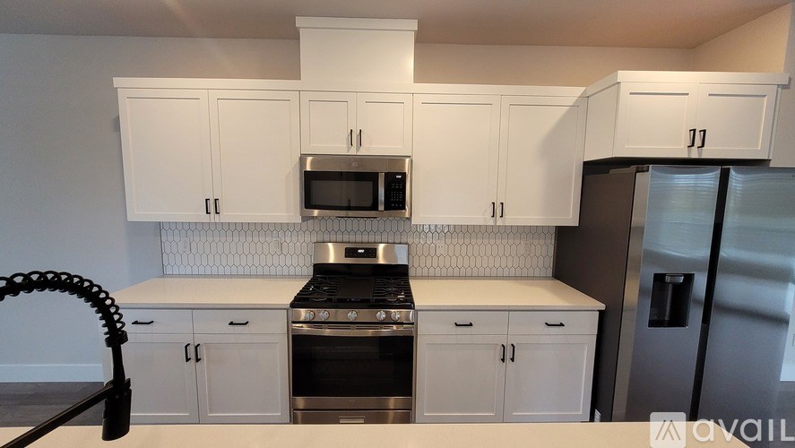 A kitchen with white cabinets and a black stove top oven.