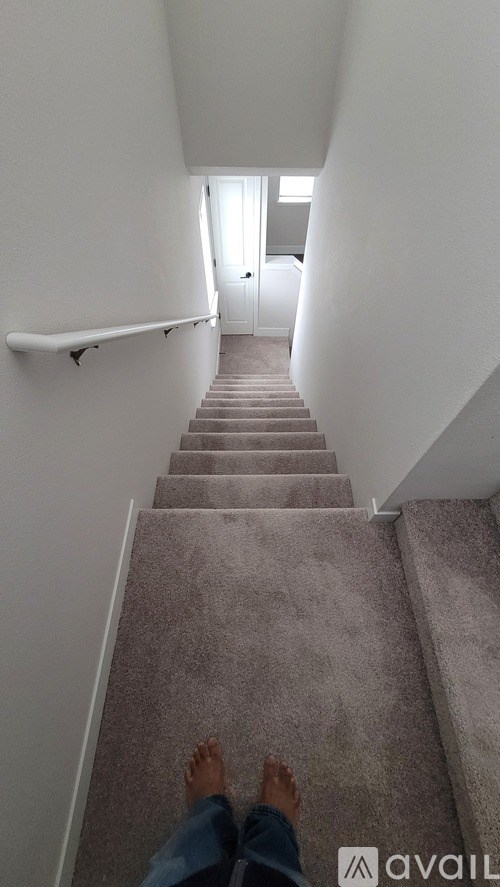 A person is standing on a staircase looking at a door.