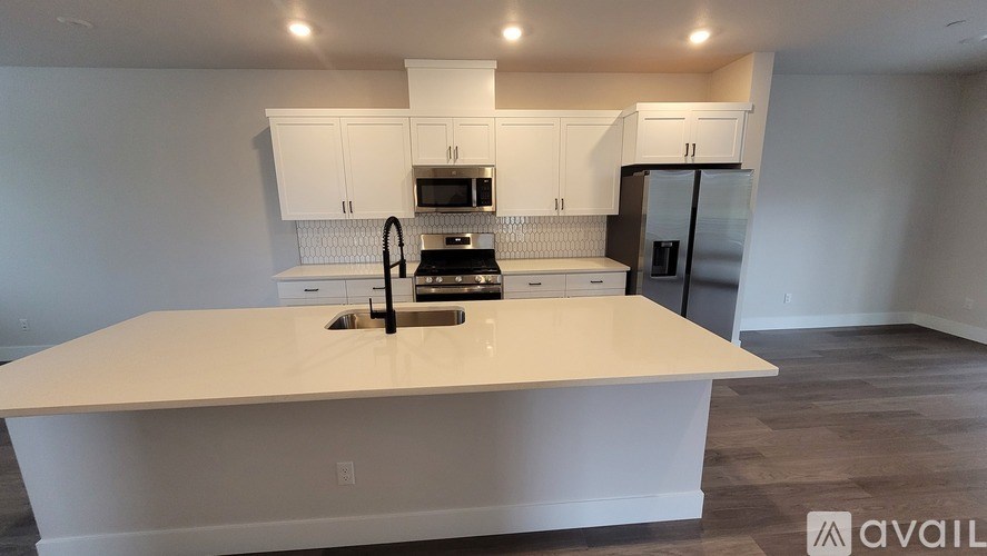 A kitchen with a white countertop and stainless steel appliances.