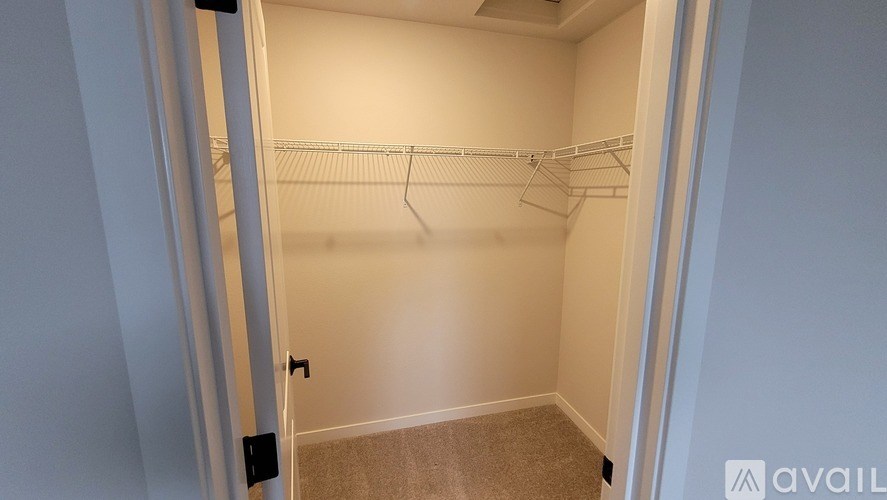 A small, empty closet with a single rod hanging from the ceiling.