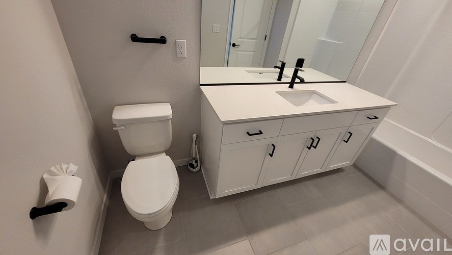 A white toilet with a toilet paper holder on the wall.