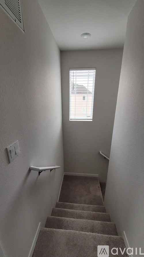 A stairway leading to a window with a house in the background.