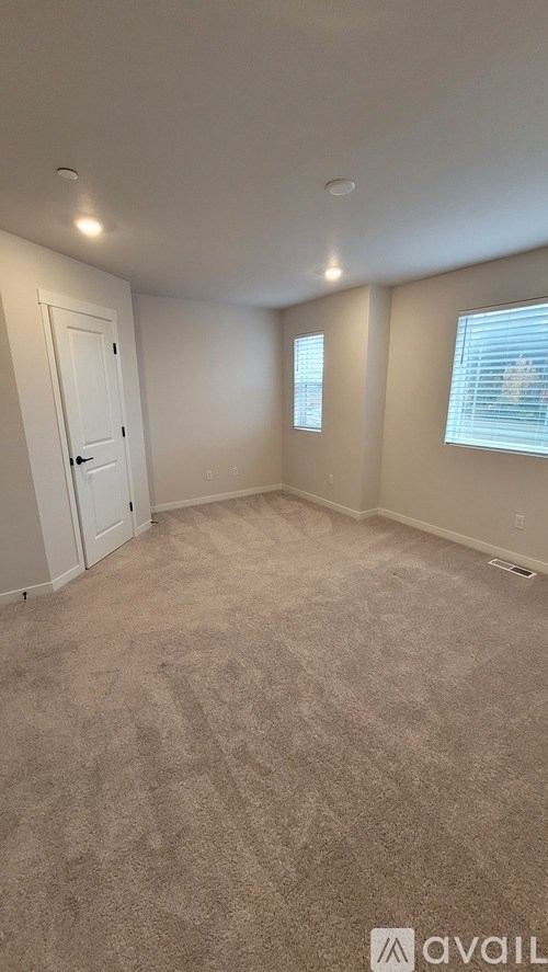 A room with beige carpet and a white door.