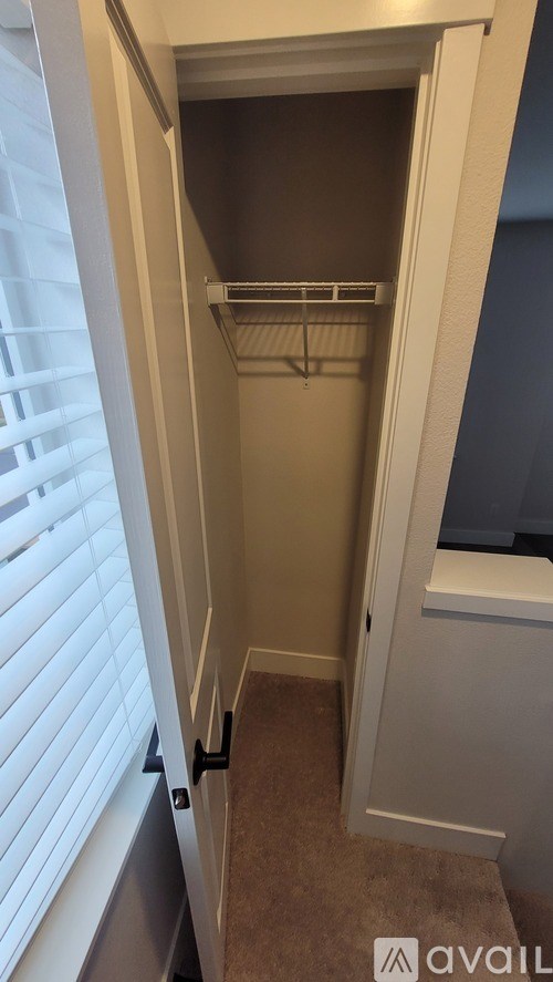 A small, empty closet with a single hanger on the rod.