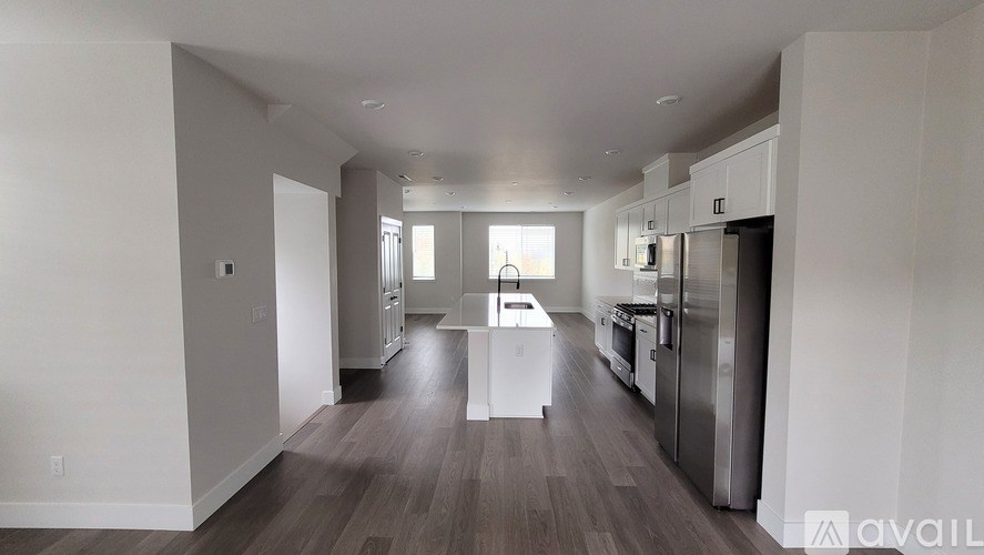 A spacious kitchen with stainless steel appliances and a dining area with a table and chairs.