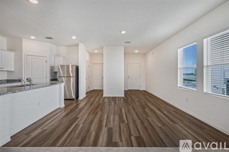 A room with a carpeted floor and sliding glass doors.