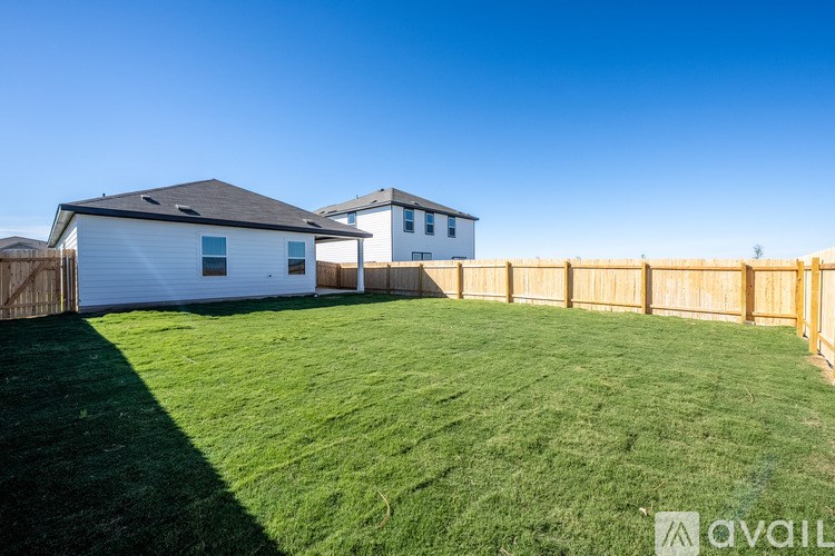 A white house with a wooden fence in front of it.