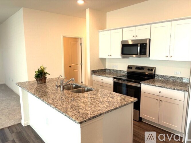 A kitchen with granite countertops and white cabinets.