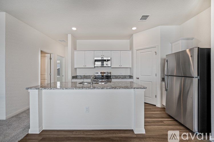 A kitchen with a granite countertop and stainless steel appliances.