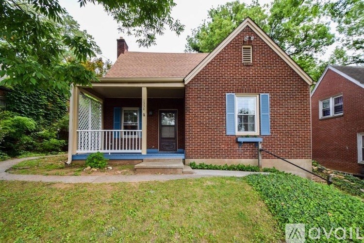 A red brick house with a blue door and a porch.