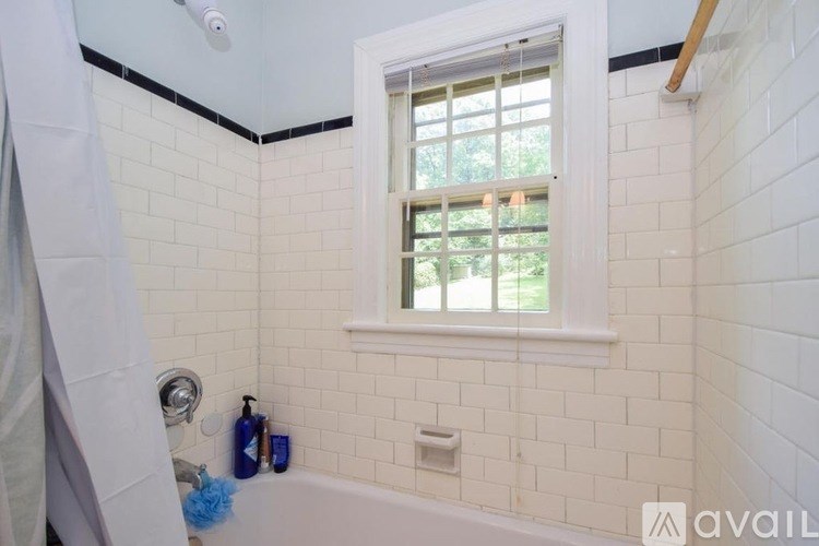 A bathroom with a window and a tub.