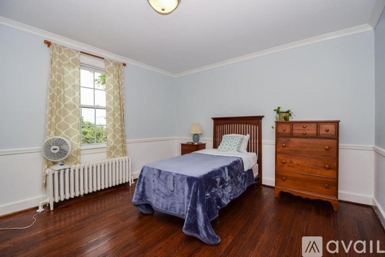 A bedroom with a bed, dresser, and window.