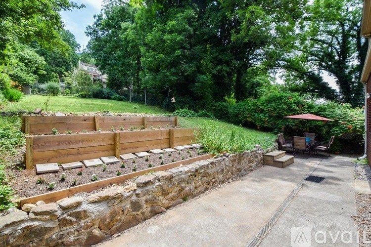 A garden with a wooden fence and a stone wall.