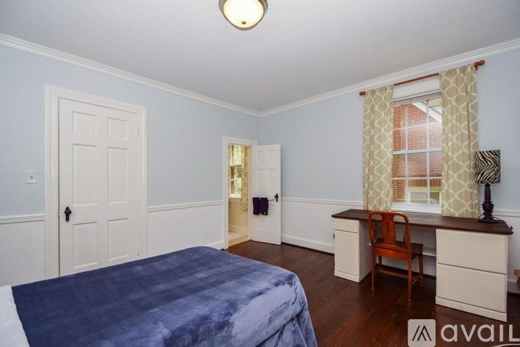 A bedroom with a bed, desk, and chair.