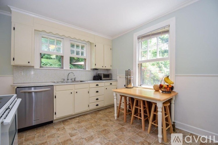 A kitchen with a table and chairs by the window.